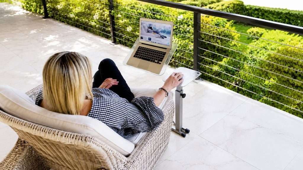 Working remotely on a covered wooden terrace surrounded by lush greenery and mountain air