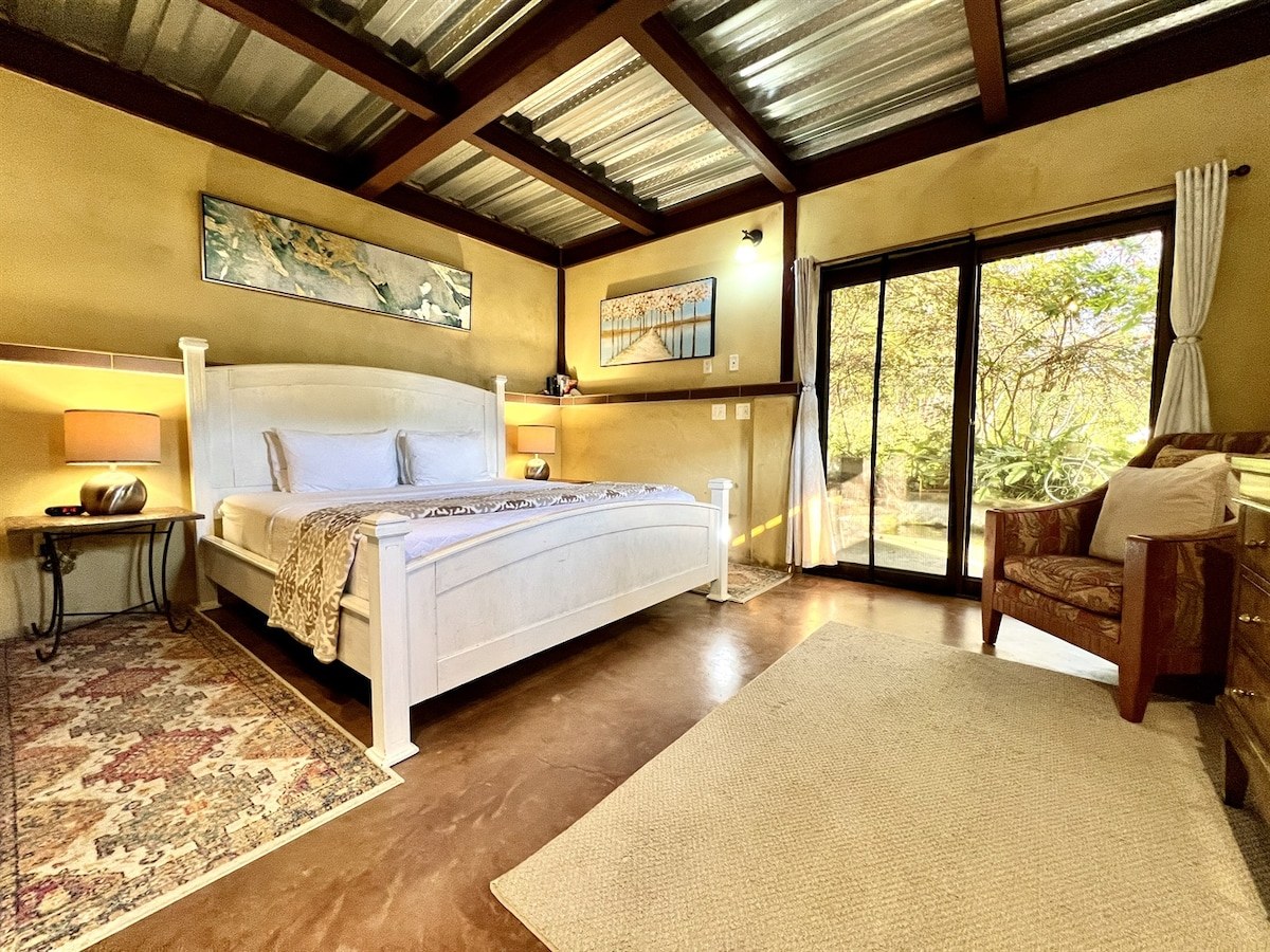 Cozy boutique wooden cabin bedroom with light-filled garden doors in Boquete